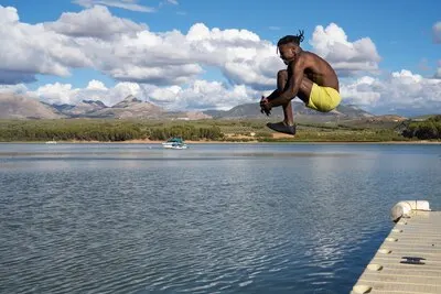 Man jumping in lake side view