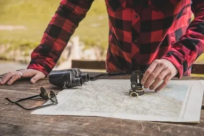 Close-up of hand with compass on a map