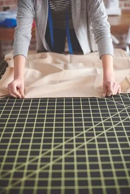 Tailor measuring fabric on the table