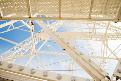 Close-up of white ferris wheel against blue sky