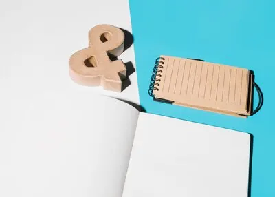 Blank page; ampersand symbol and spiral notepad on white and blue background