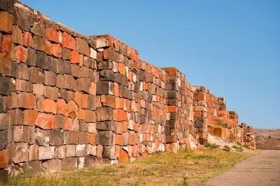 Restored walls of the ancient fortress of Erebuni the kingdom of Urartu in presentday Yerevan Armenia Traveling to popular places heritage of human history idea for banner or postcard