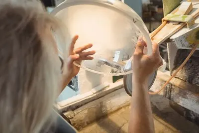 Glassblower polishing and grinding a glassware