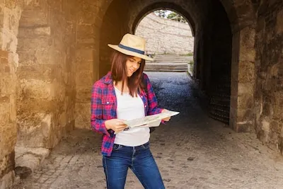 Woman wearing hat looking at direction in map