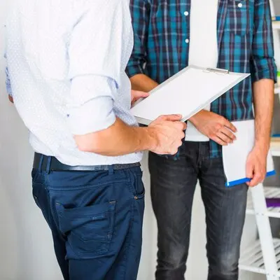 Mid section view of two businessman with folder and clipboard