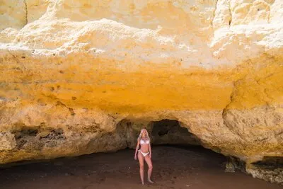 Female person sunbathing on wild rocky beach