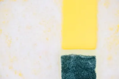 Yellow and green sponges on white soap sud