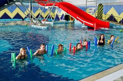Fitness group of girls doing aerobical excercises in swimming pool at aqua park Sport and leisure activities