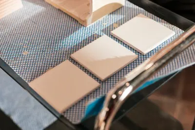 Three painted ceramic tiles on table