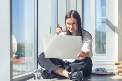 Funny young woman in front of a laptop screen in the office