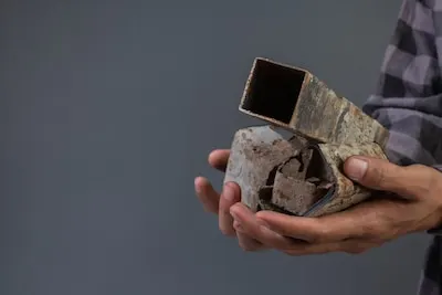 The male hand holds the old scrap iron with a gray .