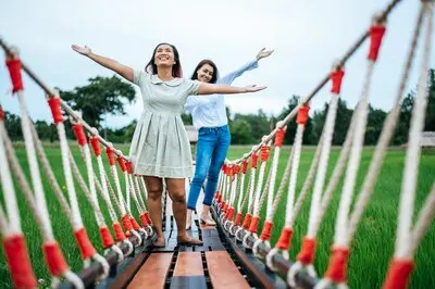 happy woman on a wooden bridge in a green meadow on a sunny day