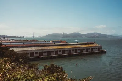 Brown and white train on rail bridge over water during daytime