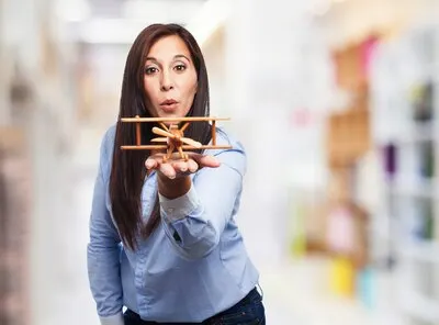 Young woman playing with a wooden biplane