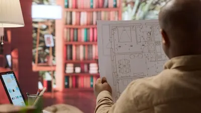 Entrepreneur analyzing architectural sketches and blueprints at his home