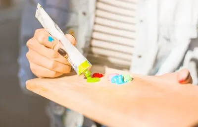 Girl putting paint on wooden board