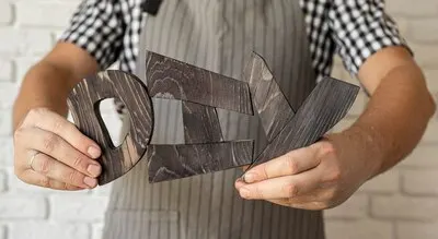 Man holding diy letters made out of wood